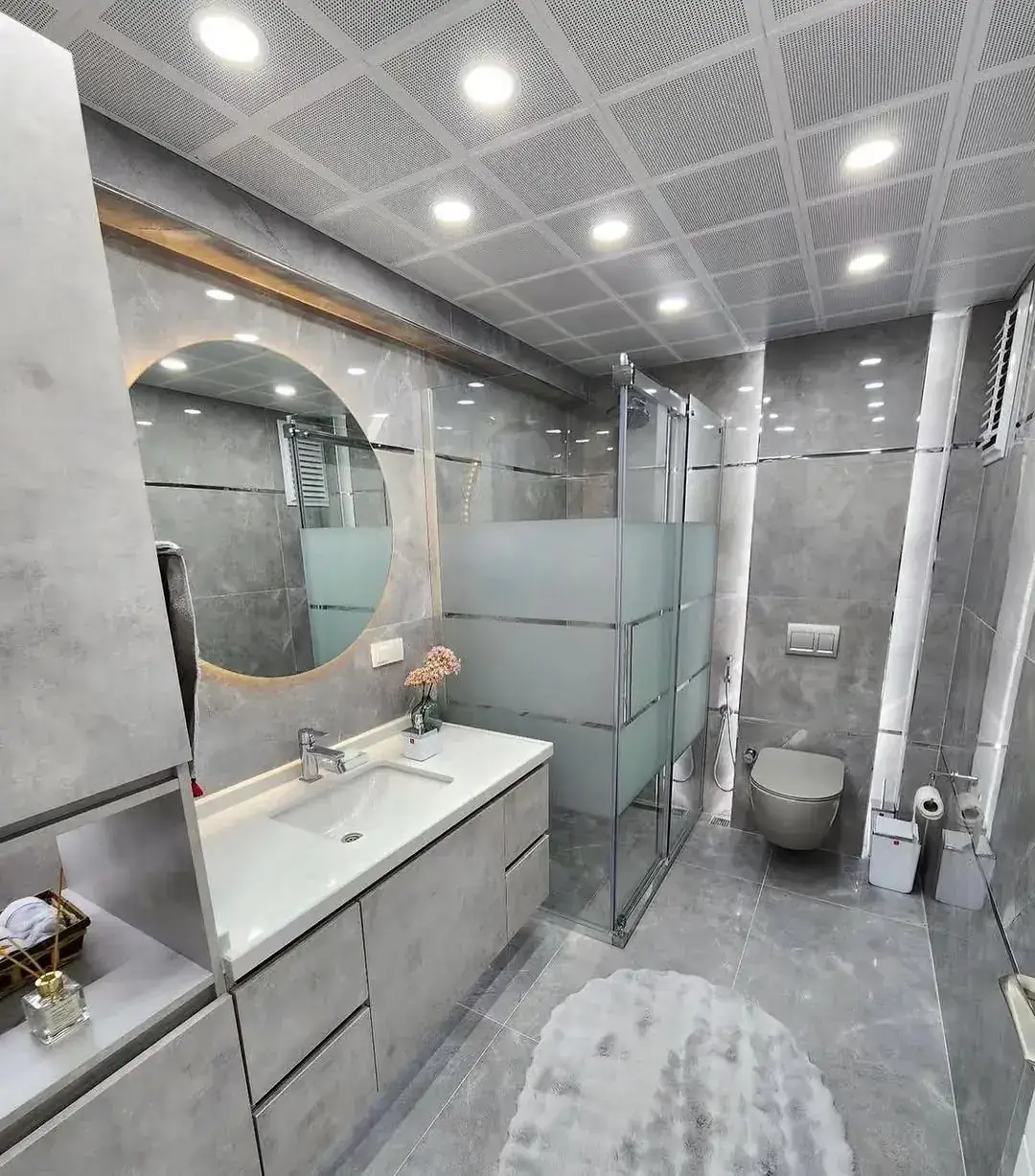Grey bathroom with round mirror
